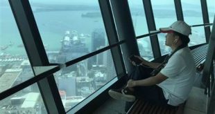 Hắn ngồi nghe nhạc từ tháp Sky Auckland. Photo My Wife